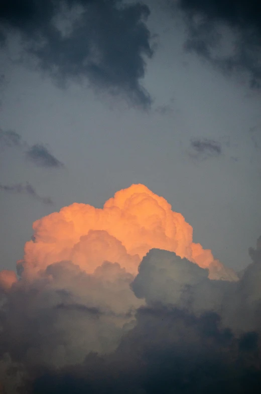 an orange cloud is seen on top of the mountain