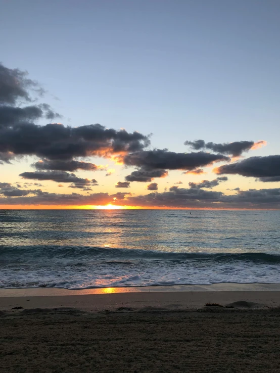 the sun is setting in the clouds over the water