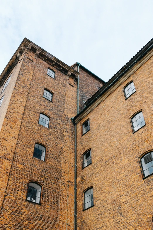 a brick building with windows and a clock on top of it