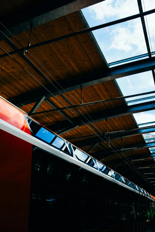 a long red train sitting at a train station