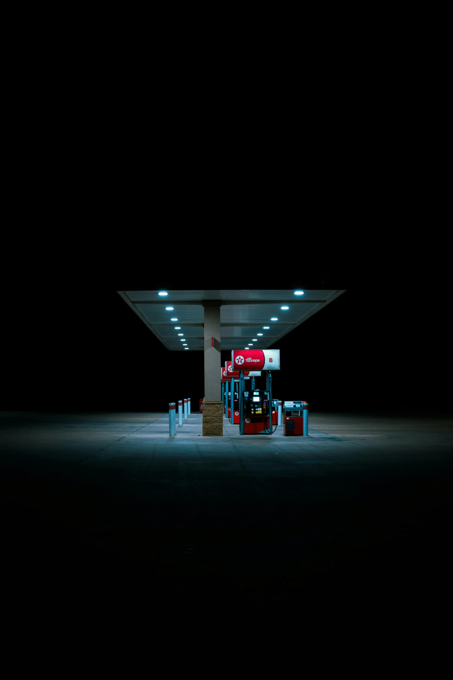 an empty gas station at night on a dark street