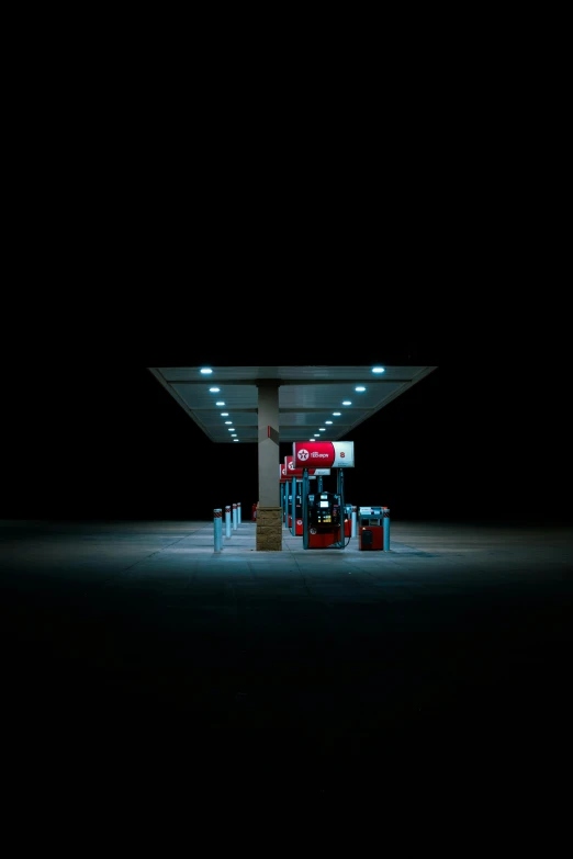 an empty gas station at night on a dark street