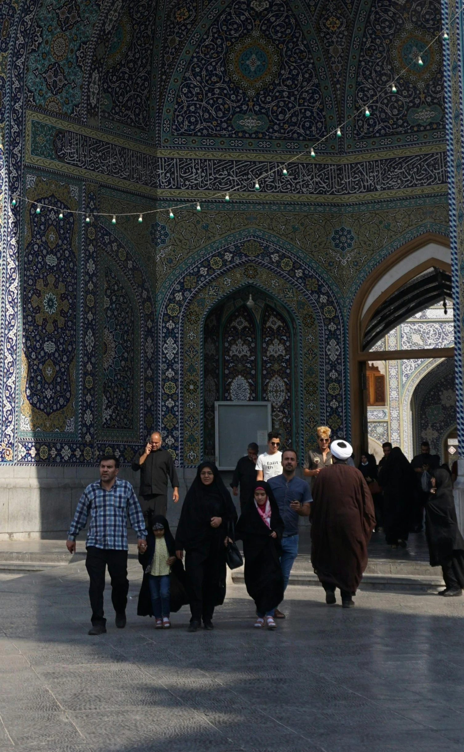 people walking around an ornate blue tile building