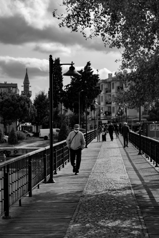 a black and white po of a person walking on a sidewalk