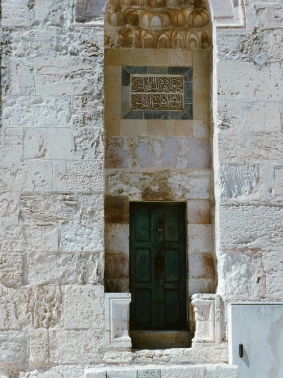 a doorway on an ancient building with green door