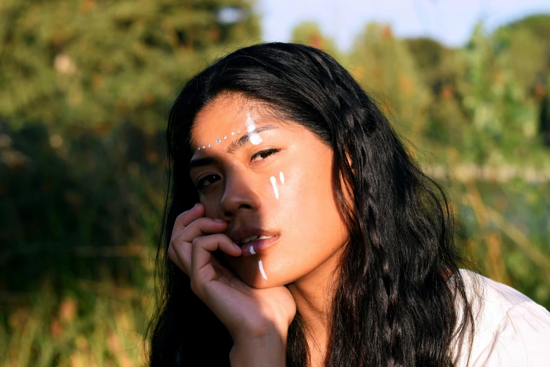 a woman with white face paint and long dark hair