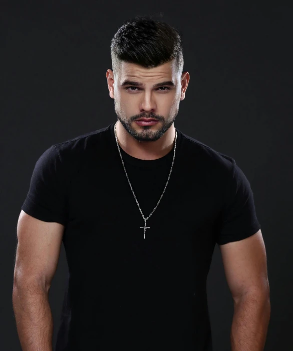 a young man posing in a black tee shirt with a cross on his neck