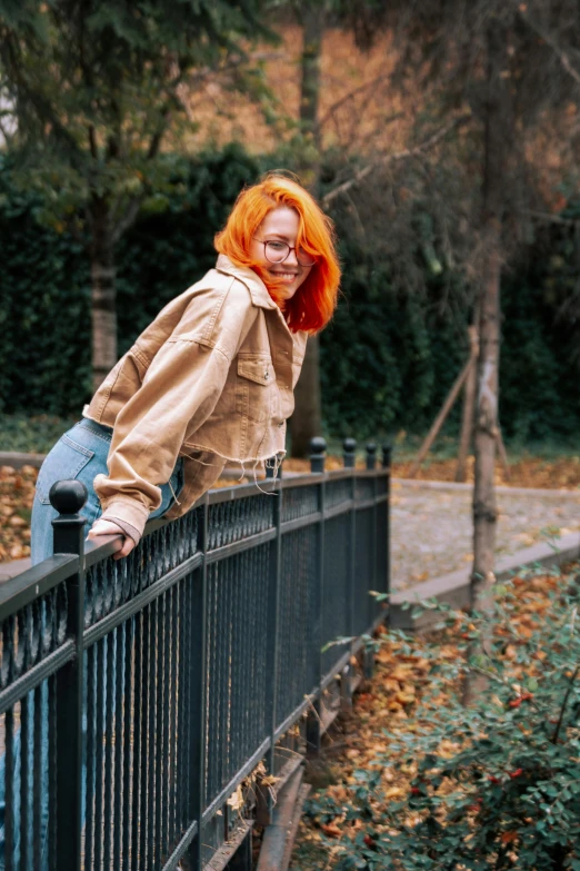 the woman with orange hair is posing on the bridge