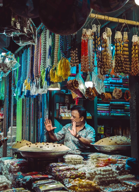 a man looking through a shop display at celets and necklaces