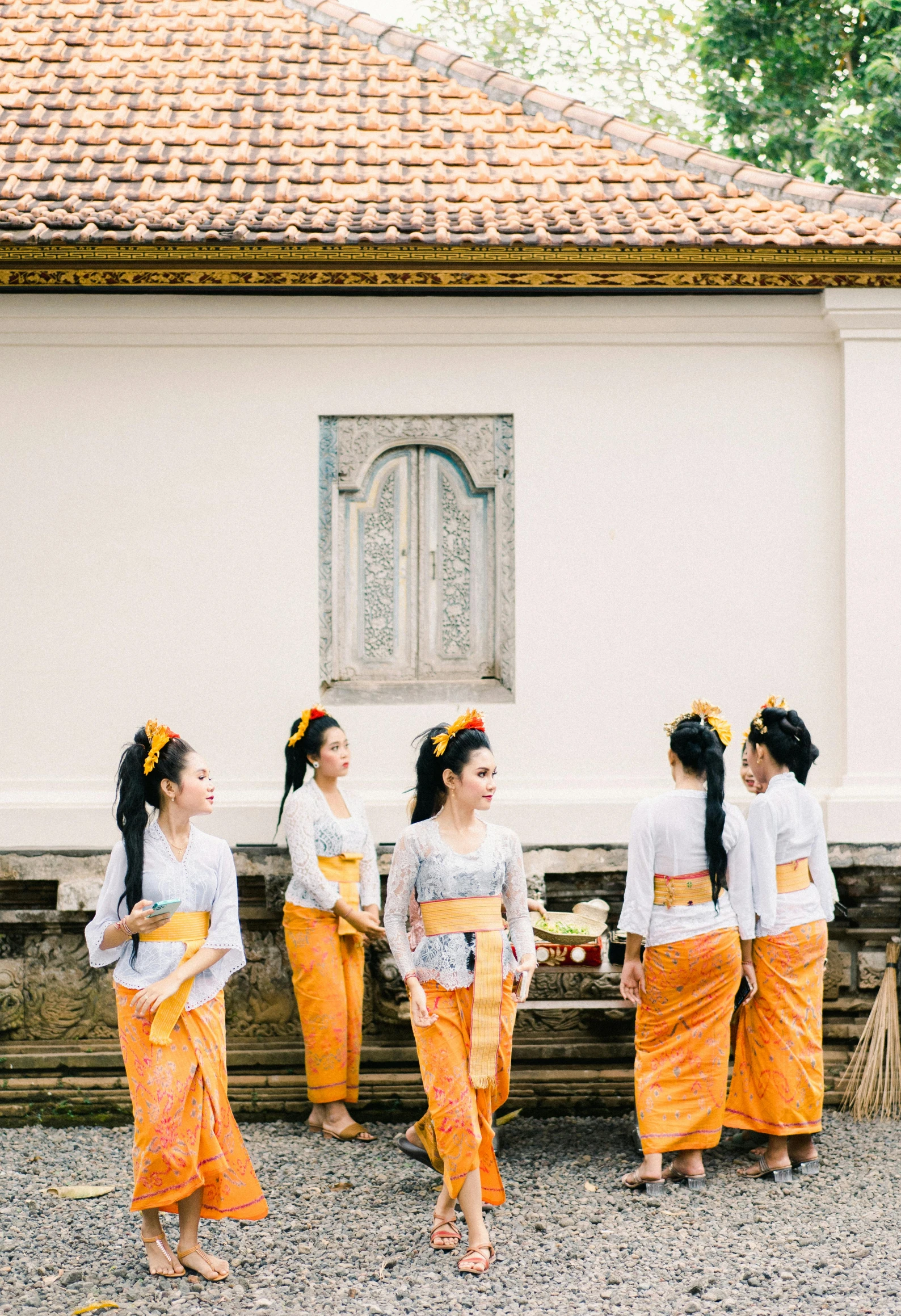 four girls in traditional garb standing outside