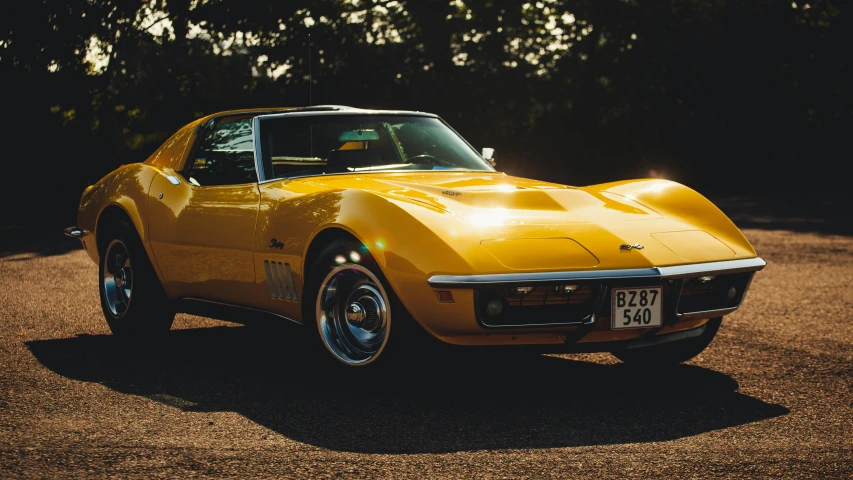 the yellow corvette is parked in a parking lot