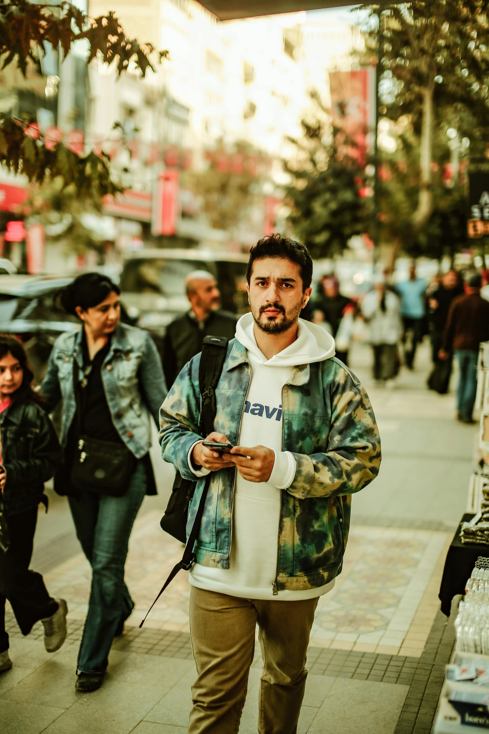 a man is walking on the street with a phone