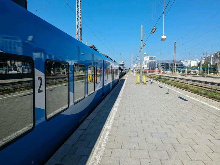 a blue train sits at a train station