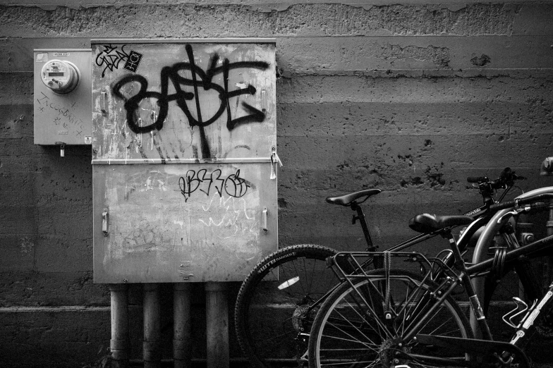 black and white pograph of bicycles, a box with graffiti