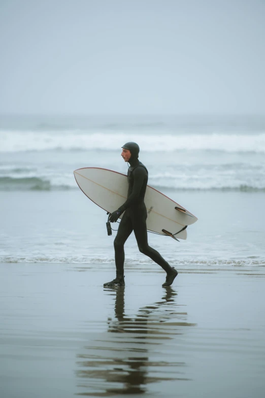 surfer walking on the beach with surfboard in hand