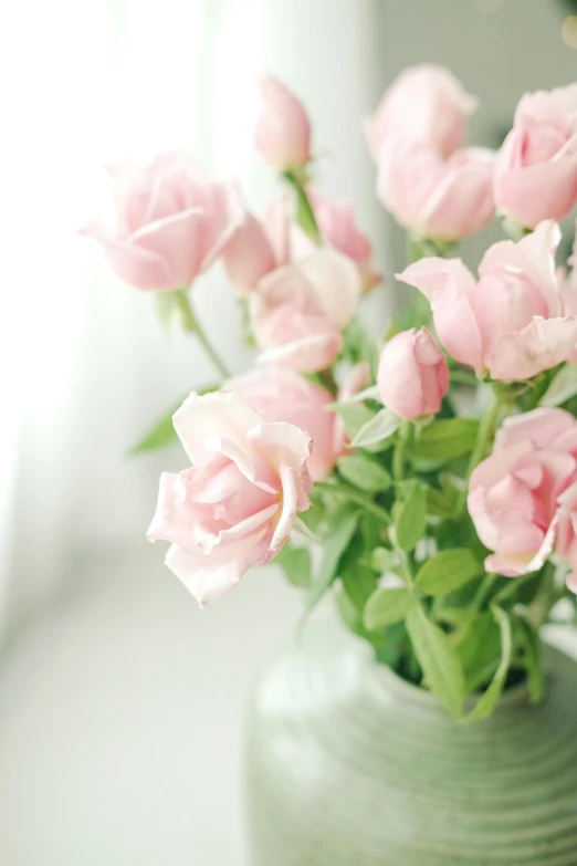 pink flowers are in a glass vase on the table