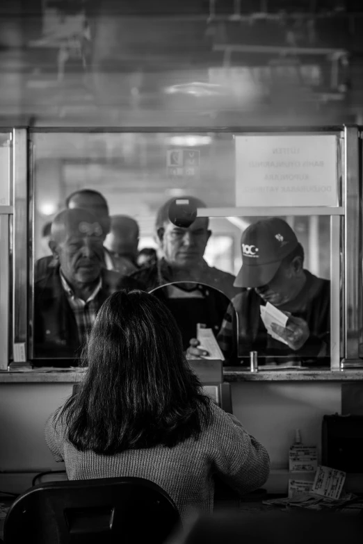 a group of people standing at a counter talking to each other