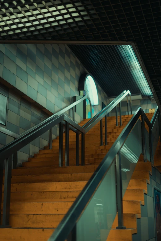 a stair rail in a subway station with tiled walls