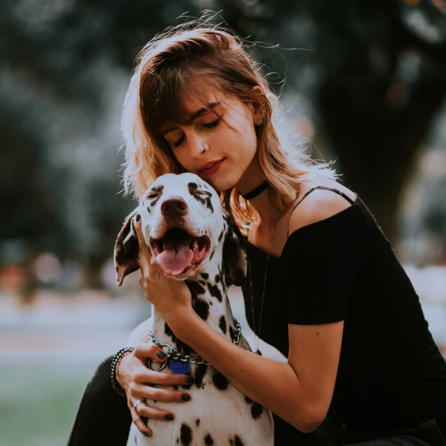 a lady petting a dog at the park