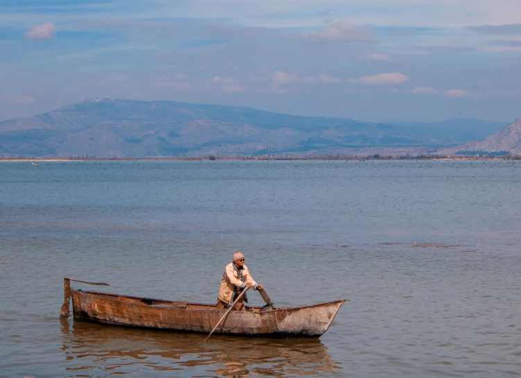 a man is riding in a small boat on the water