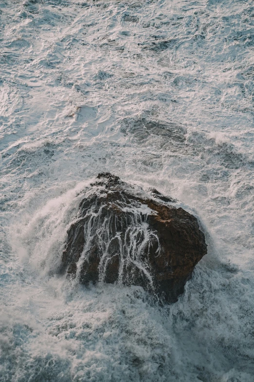 the rocks in the water are covered by snow