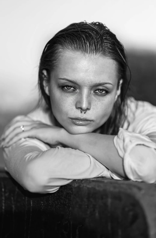 the black and white po shows a woman posing in a shirt with her arms crossed