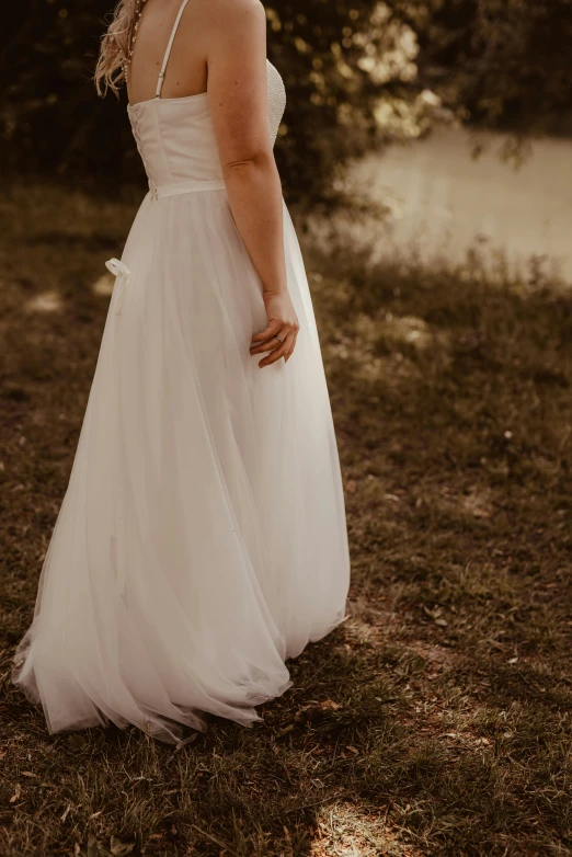 a woman is in the grass with her back turned