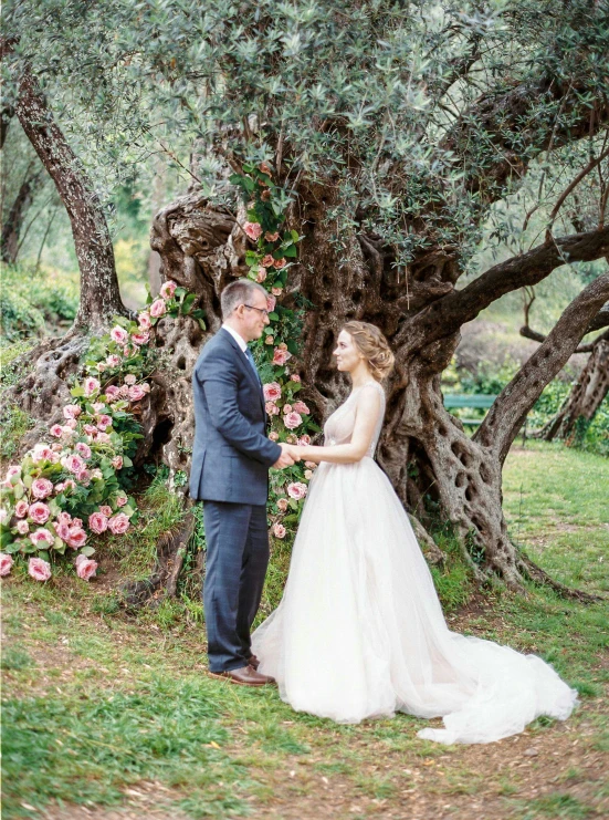 a newly married couple in front of some trees