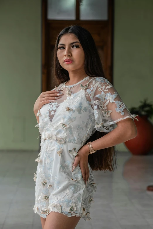 a woman in a short white dress posing for a po