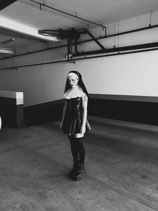 a girl poses for a black and white po while hanging around a large pipe