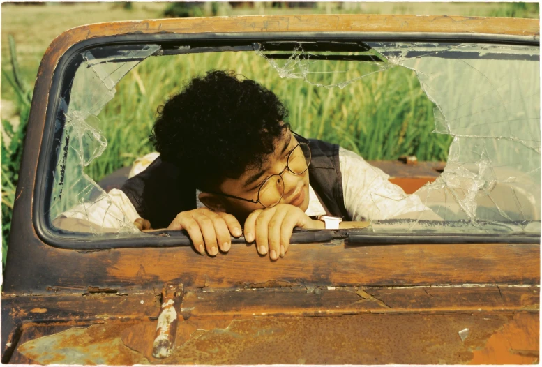 man leaning on rusted truck window with face pressed out