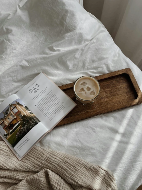 the open book is resting on top of the bed