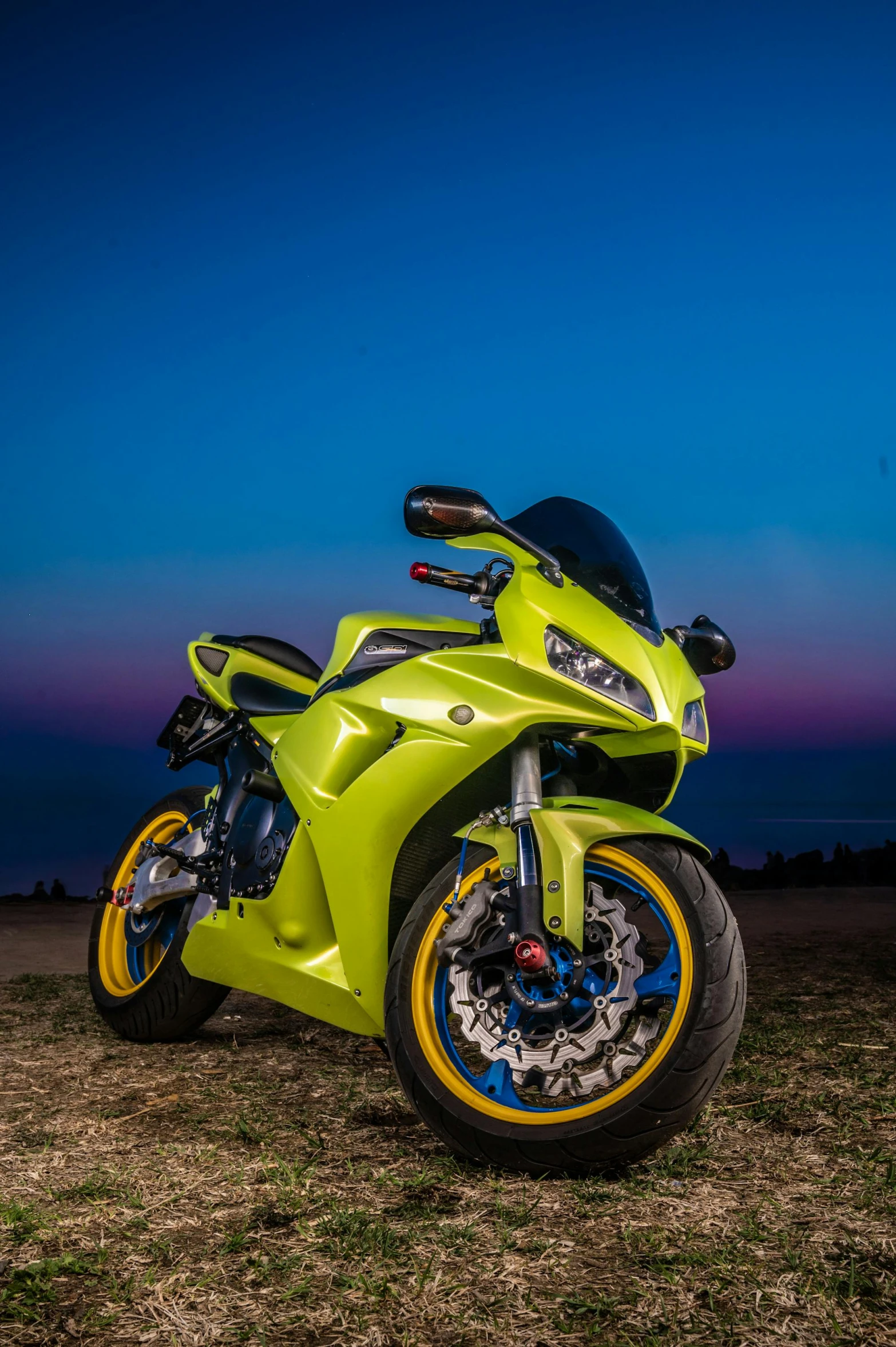 a bright yellow and blue sports motorcycle is parked