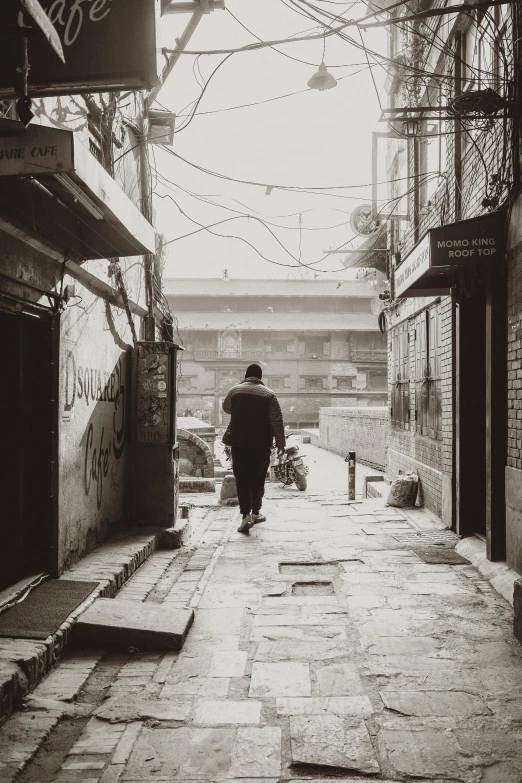 a man walking down a narrow stone street