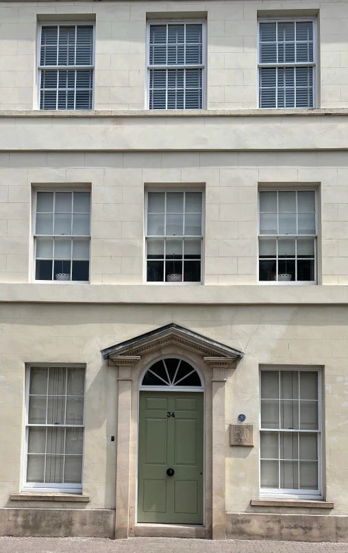 the large white building is painted with a green door