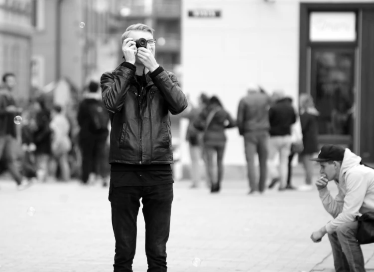 a black and white po of a man taking a po of the sidewalk