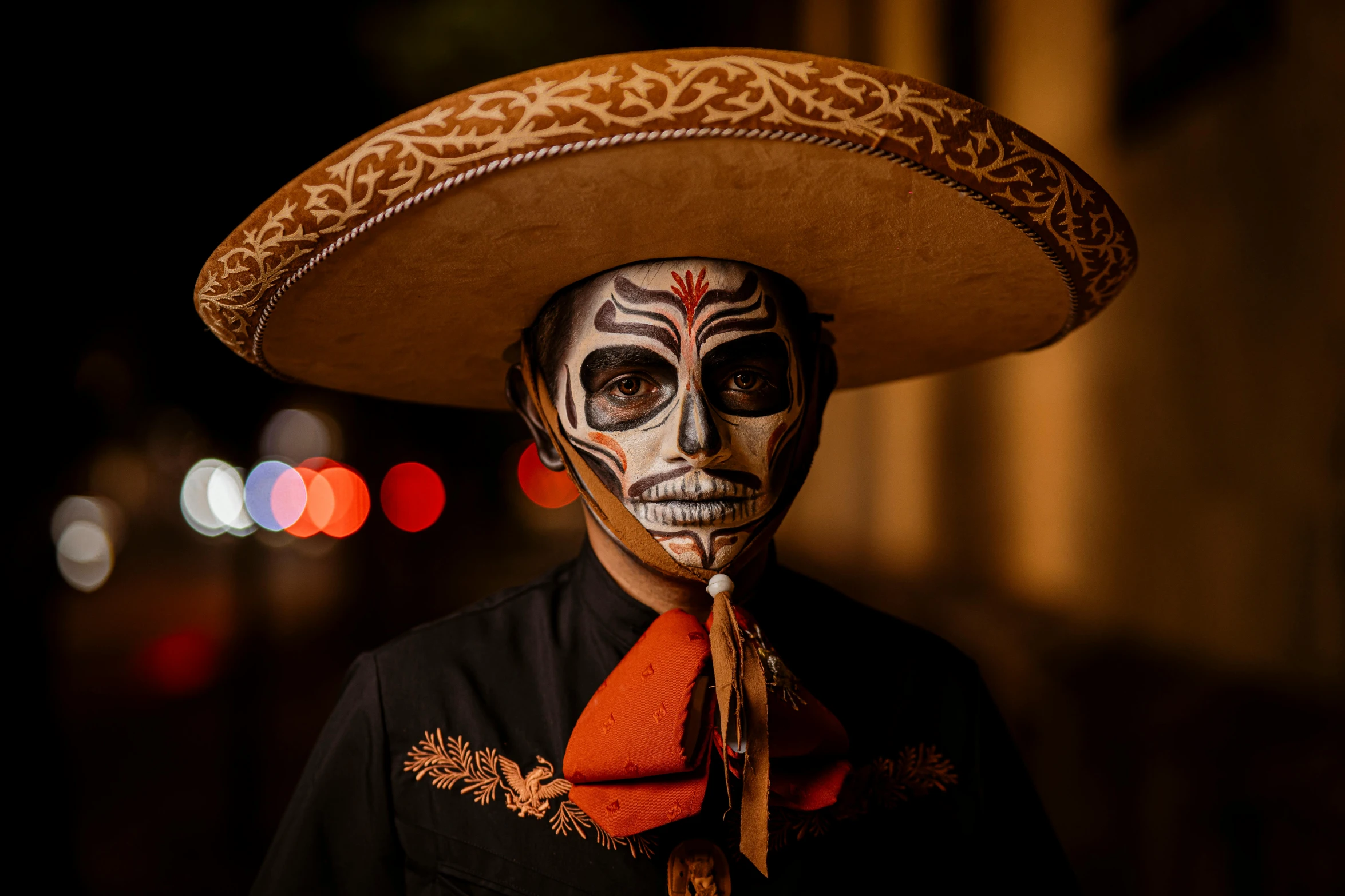 a man wearing a sombrero and wearing orange scarf