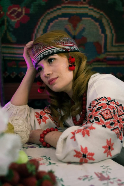 young woman with red flowers on head laying on white bed