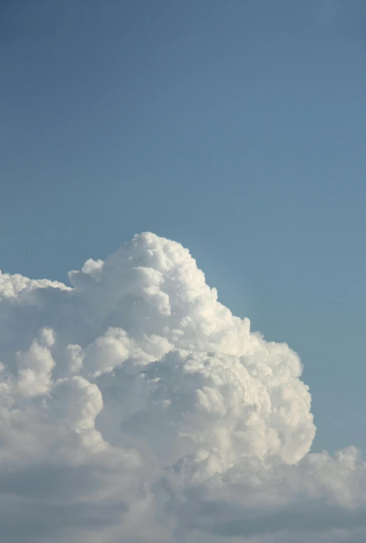 an airplane flying above a large cloud in the sky