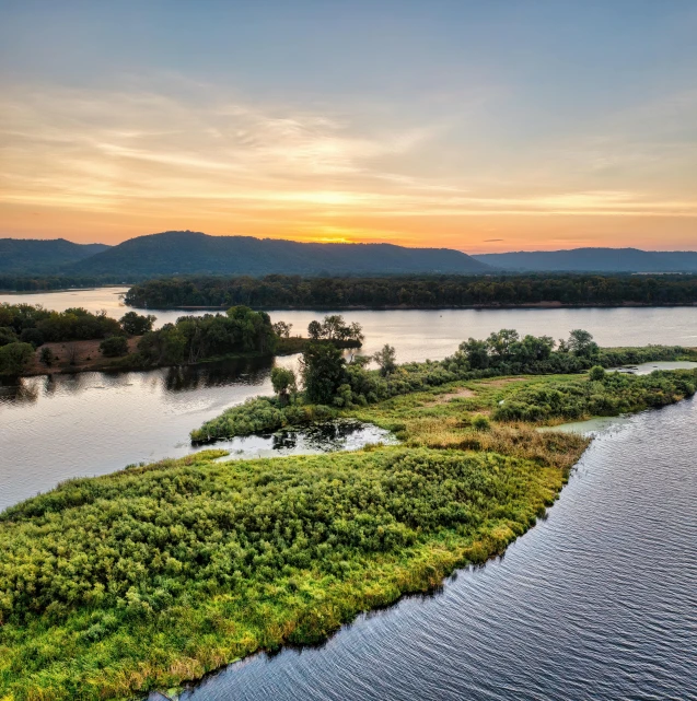 an island near a body of water with grass in the foreground