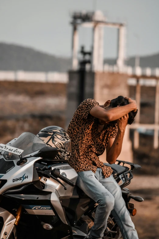 a man sitting on a motor cycle leaning up