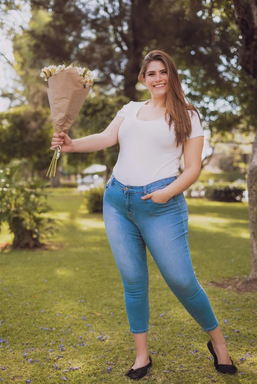 a beautiful woman holding a bouquet of flowers and posing for the camera