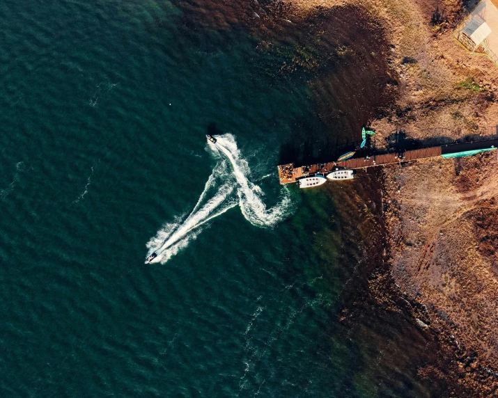 a boat sailing on the ocean next to a beach