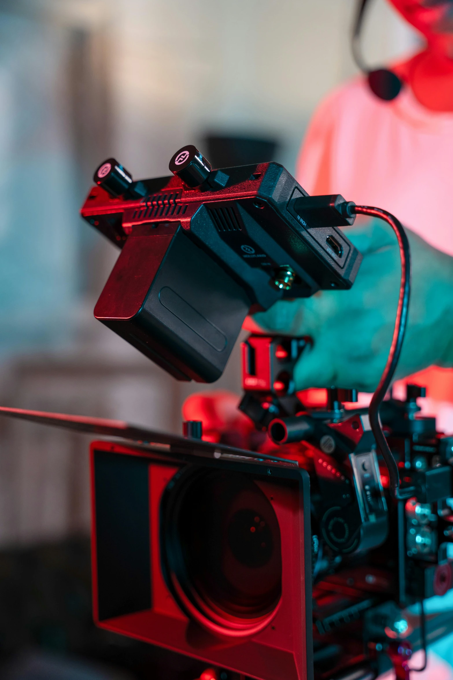a red camera being held over a hand with an arm holding a device