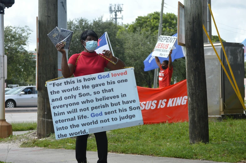 two people holding signs that read for this is how god crowd