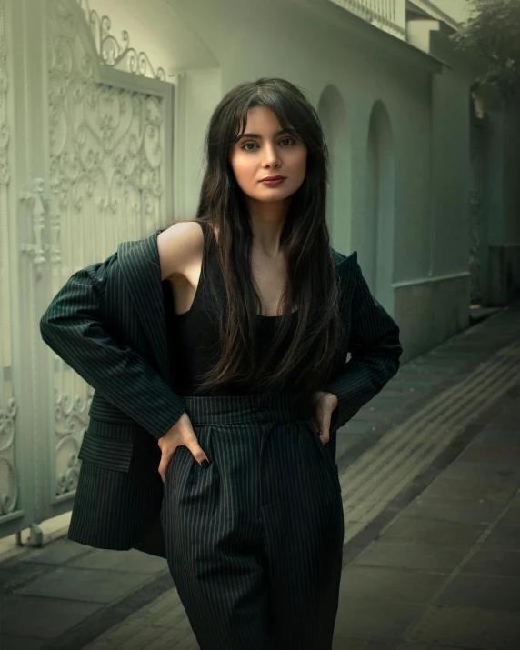 a woman standing on the street next to a building