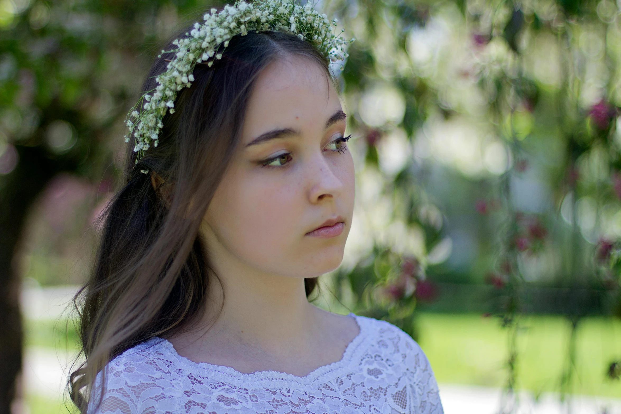 a young woman wearing a headband made out of flowers