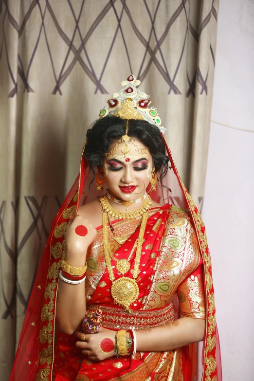 a bride dressed in a red sari with a red headpiece