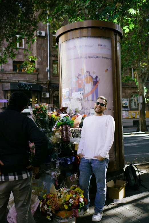 a man is selling flowers by a street corner