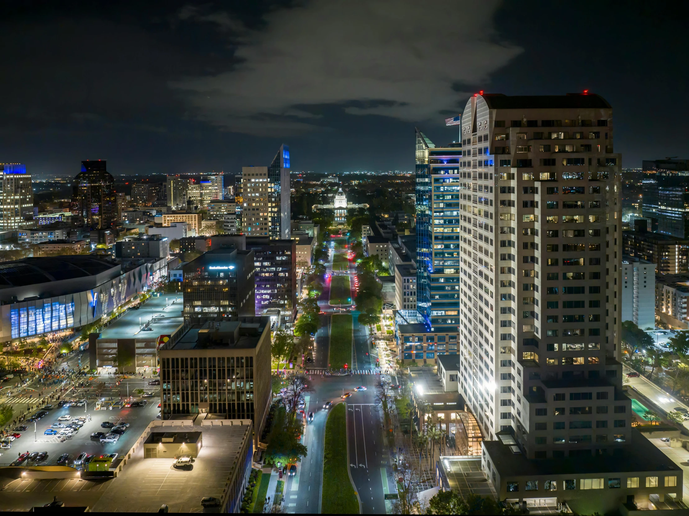 an aerial view of city at night, looking towards the streets